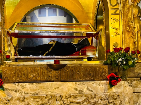 St. Rita's incorrupt body in the Basilica in Cascia, Italy with detailed carvings on front and roses.