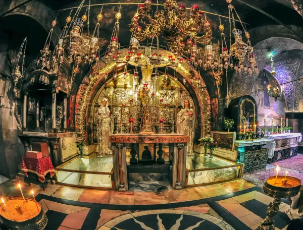 An image of the glittering candle-lit Holy Sepulcher in Jerusalem.